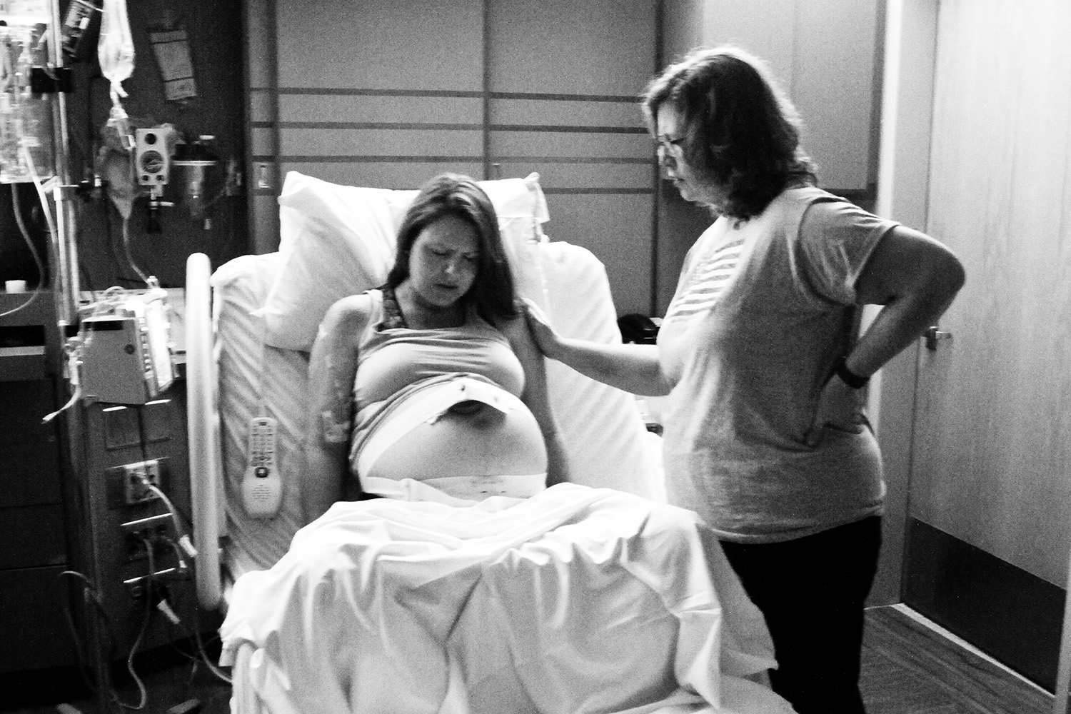 Woman in Labor with a Birth Doula by her sid