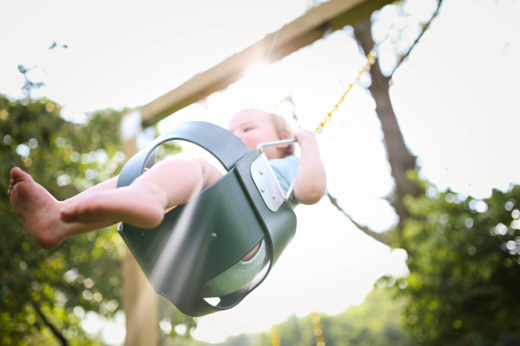 Toddler swinging during 1000 Hours Outside Challenge 2021